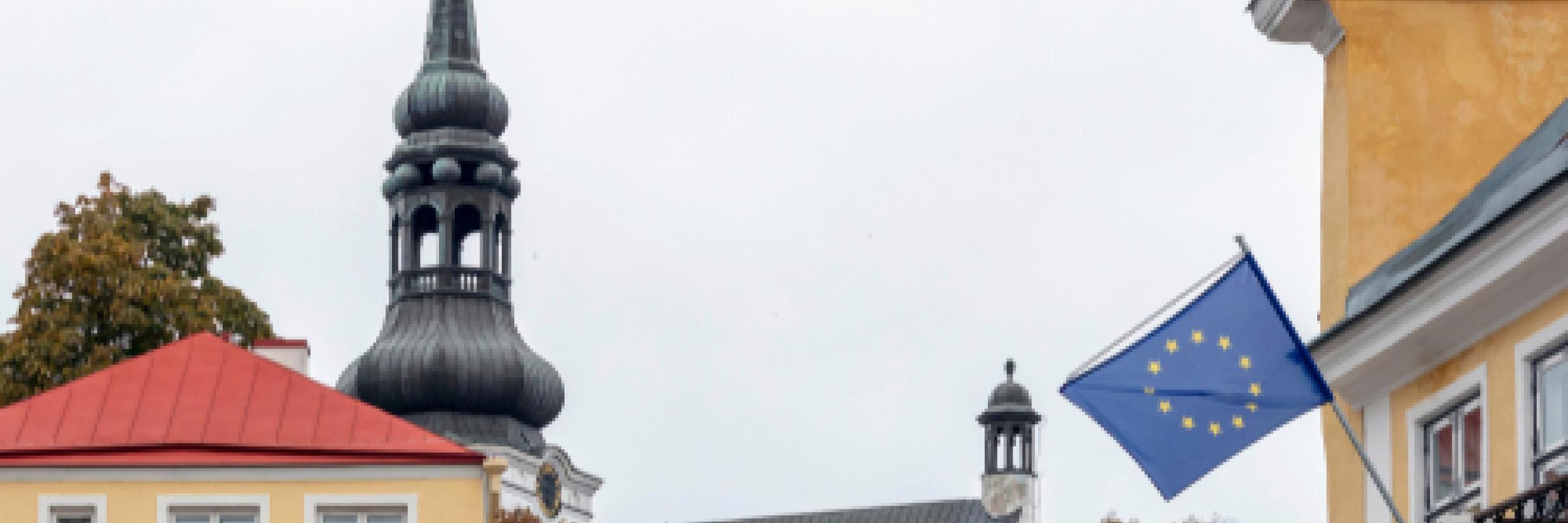 Image of the EU flag and some roofs of buildings