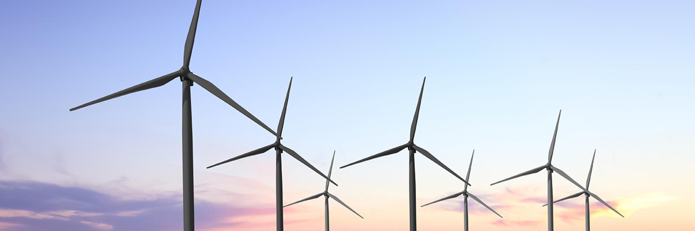 a row of wind turbines in a field.