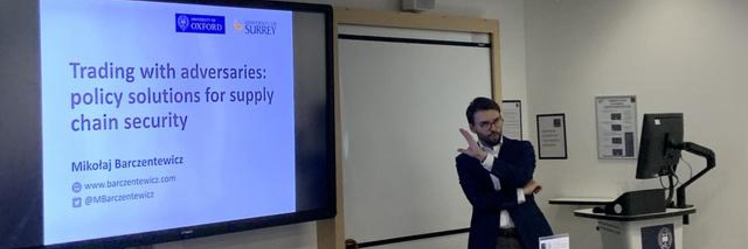 A man presenting in front of a screen