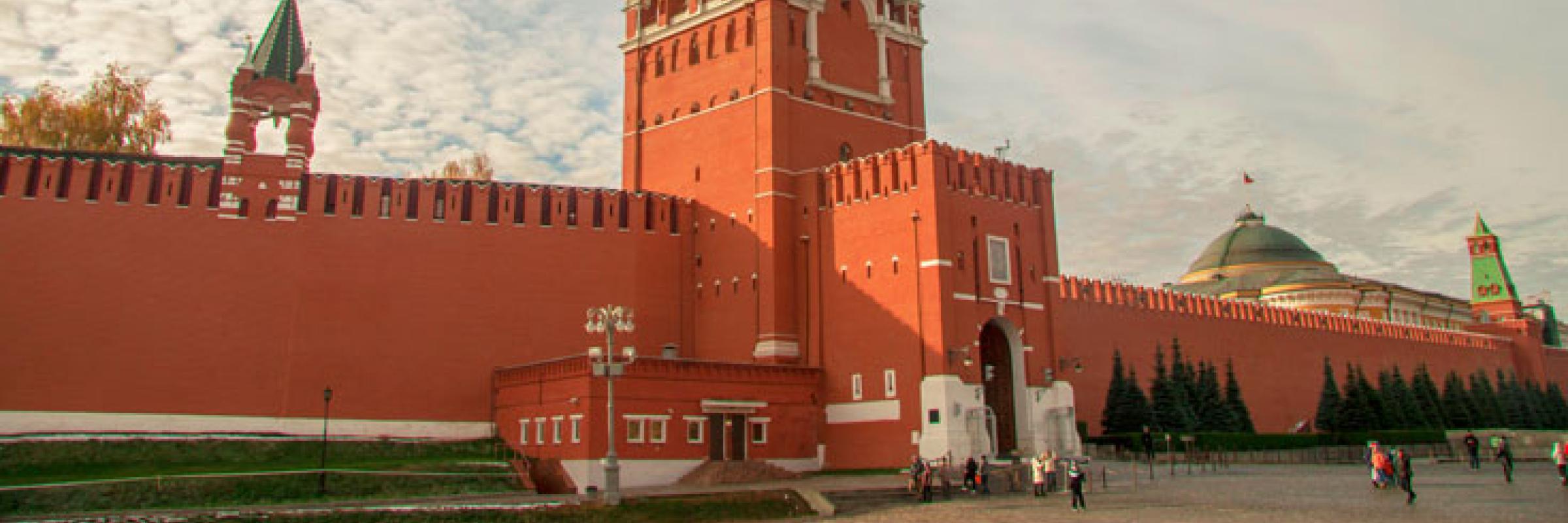 The red wall of a large building with a clock tower