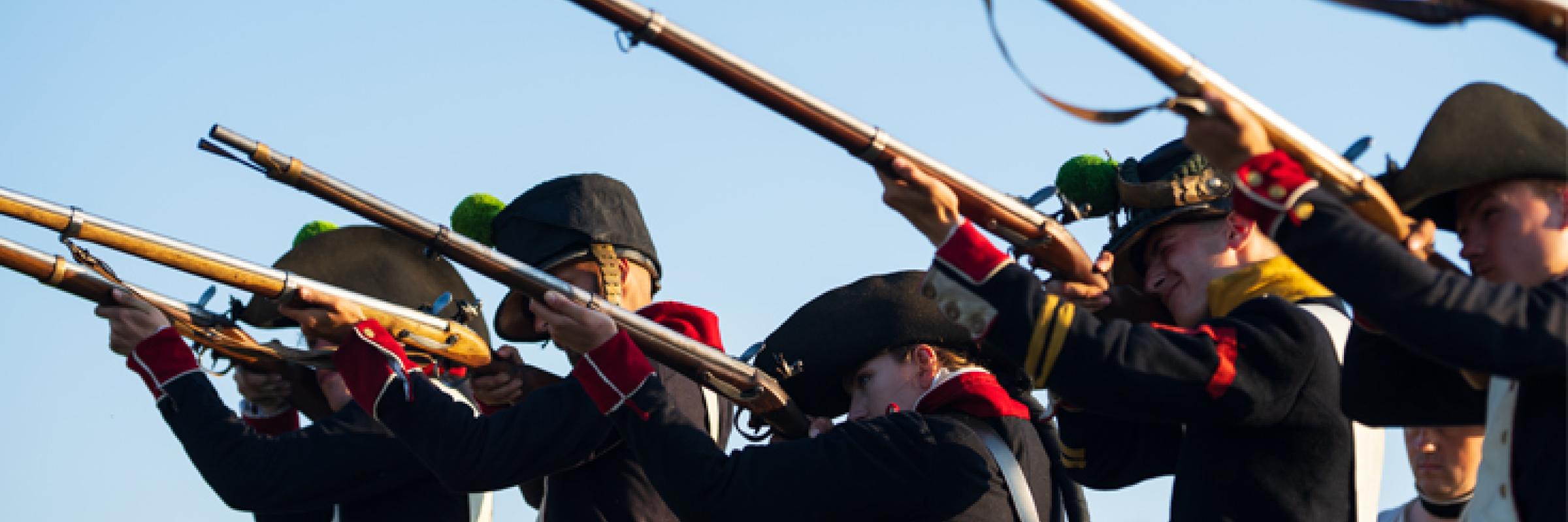 A group of men in uniform holding guns. 