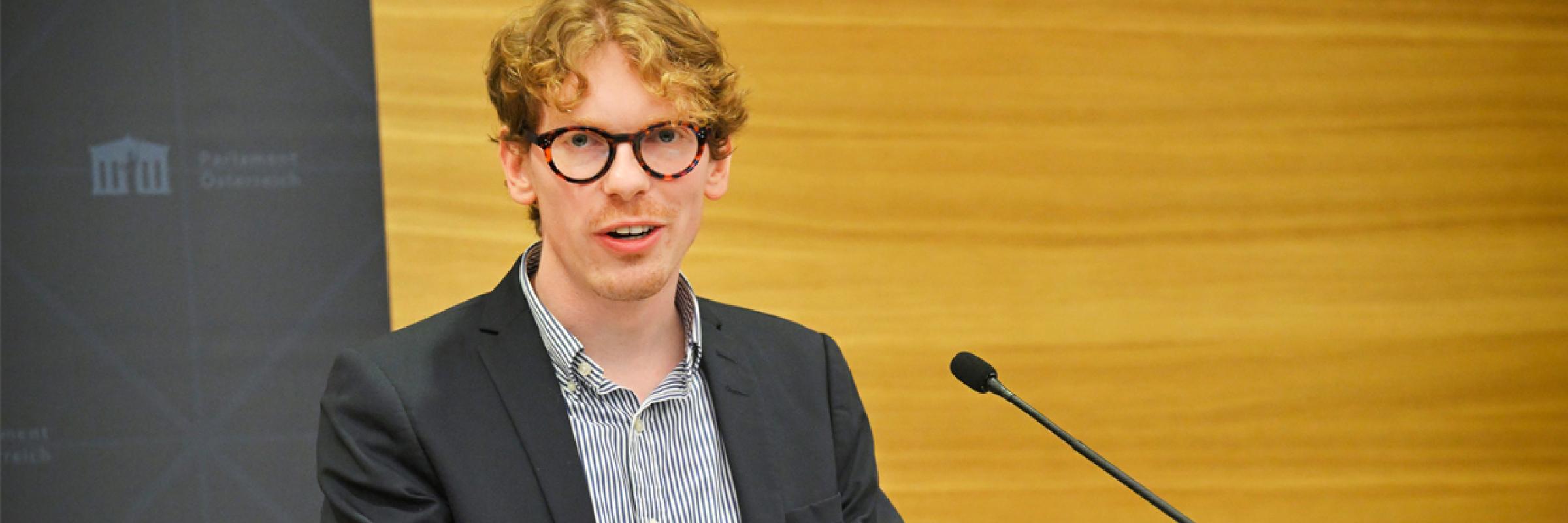 A person standing at a podium with a computer.