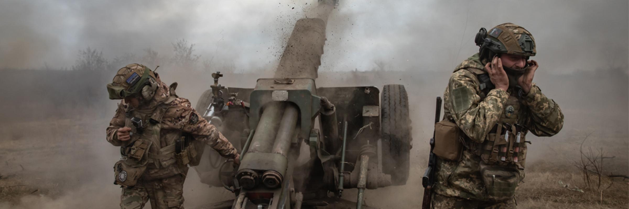 A group of soldiers in uniform standing next to a cannon.